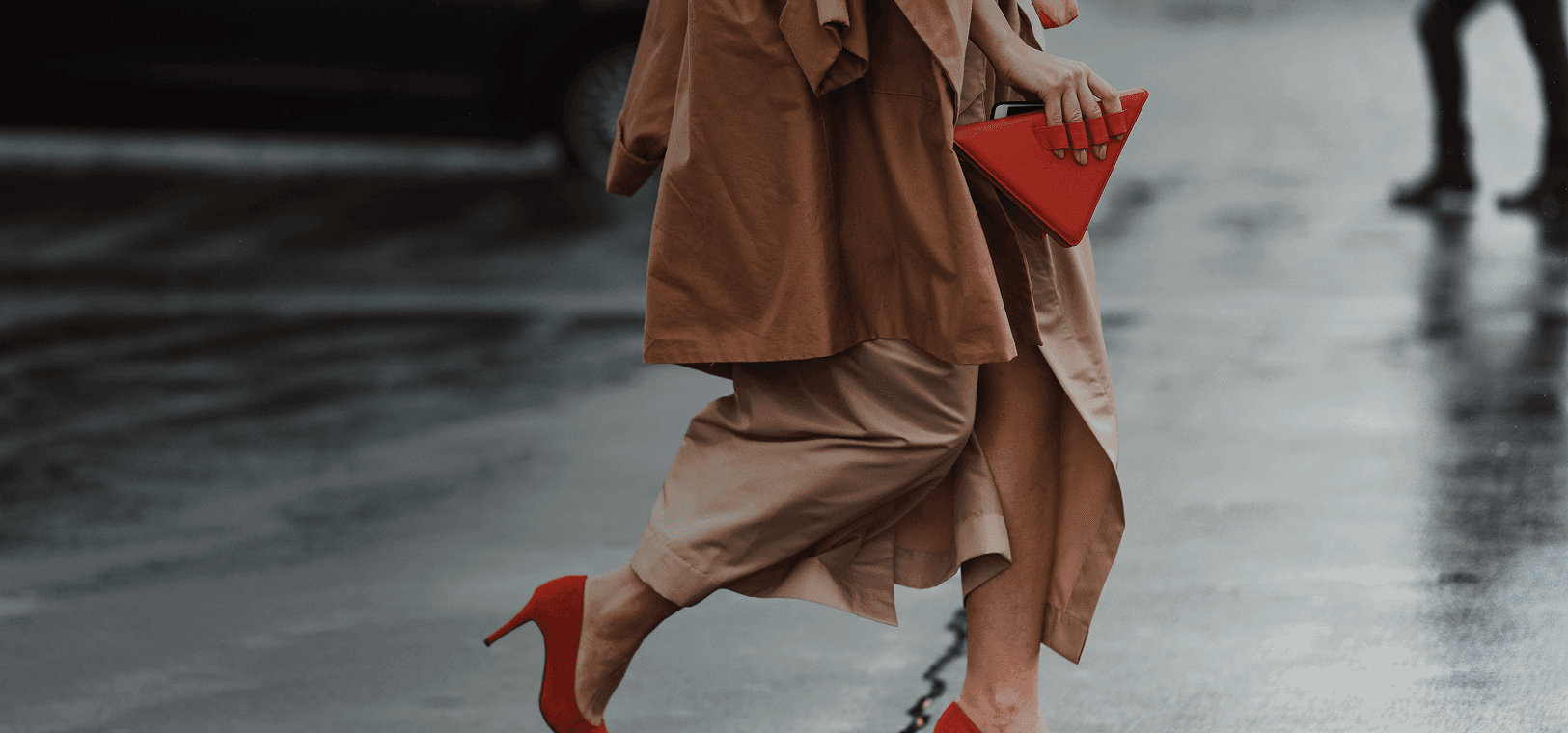 Una mujer bien vestida, con hermosos tacones altos rojos y un bolso rojo de moda, cruza la calle. Se superpone la frase francesa "bien habillé" con su traducción al español, "bien vestido".