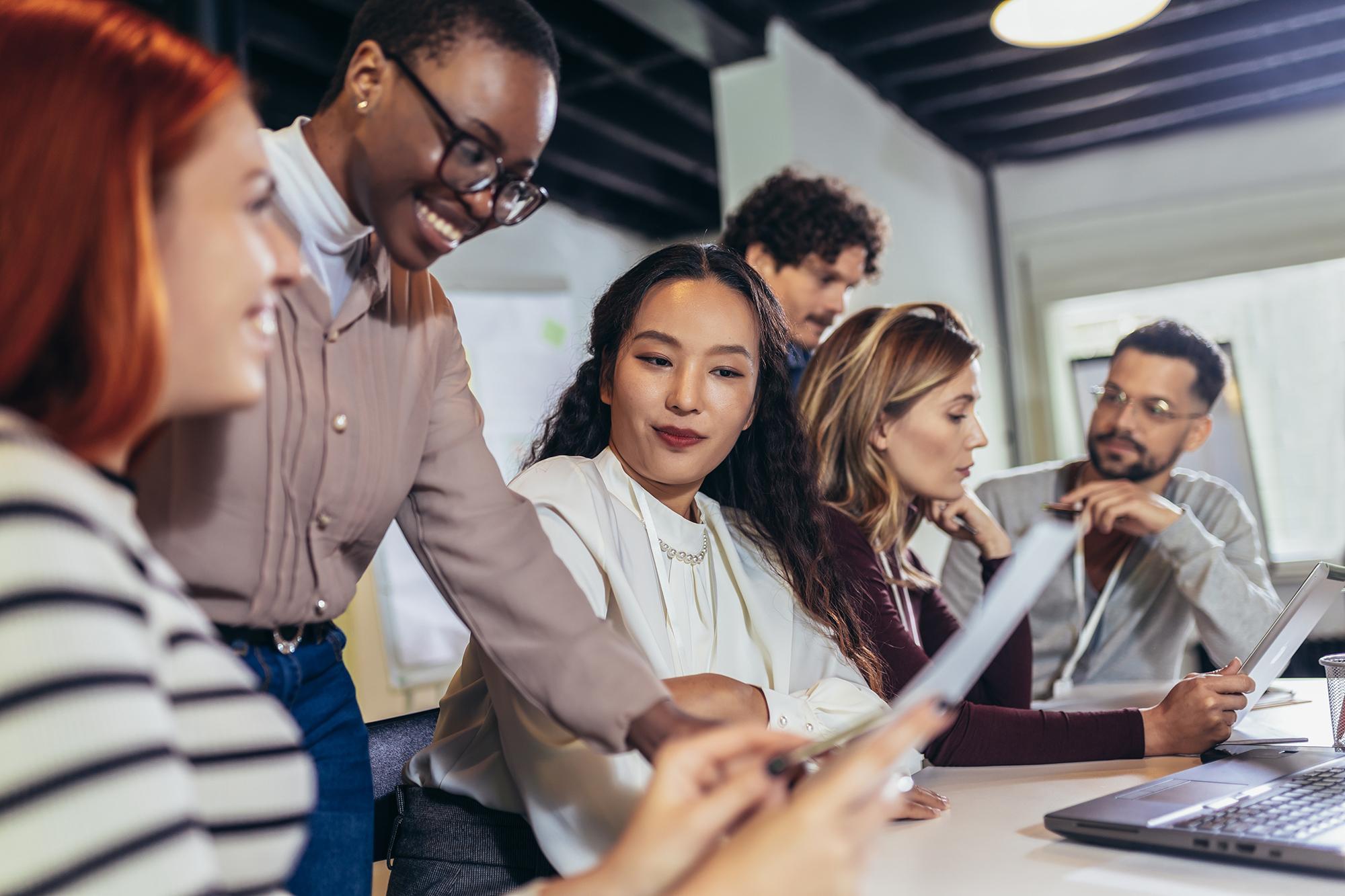Un grupo de profesionales colaborando en una reunión es indicativo del programa de aprendizaje de idiomas de Rosetta Stone para empresas, que mejora la comunicación y las habilidades en el lugar de trabajo.