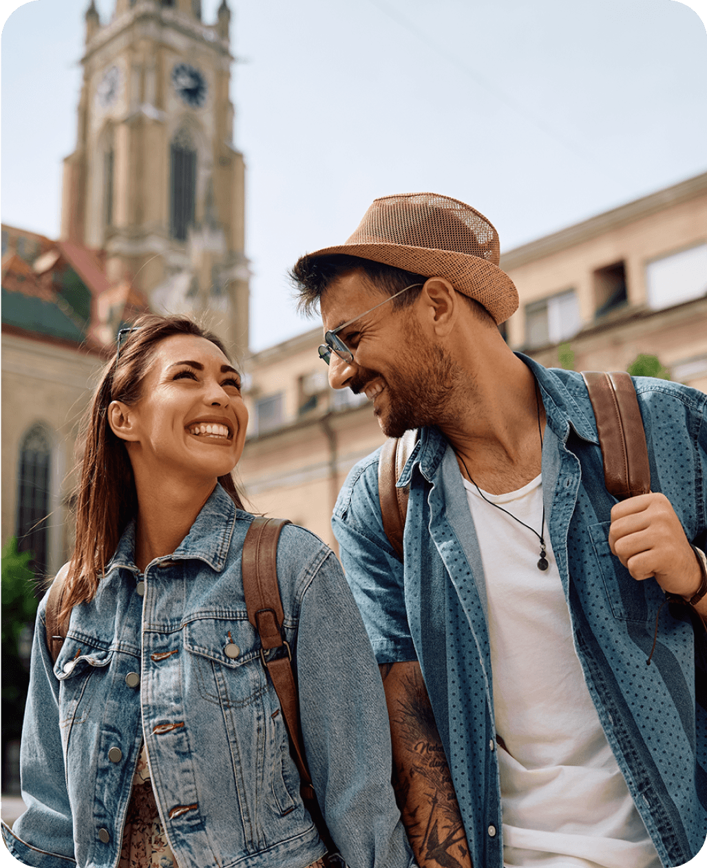 Una pareja sonriente dando un paseo por el exterior significa el uso del idioma en el mundo real.