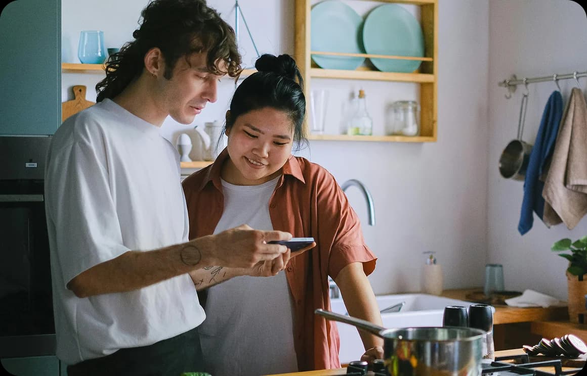 Dos personas aprendiendo juntas, usando un dispositivo móvil.